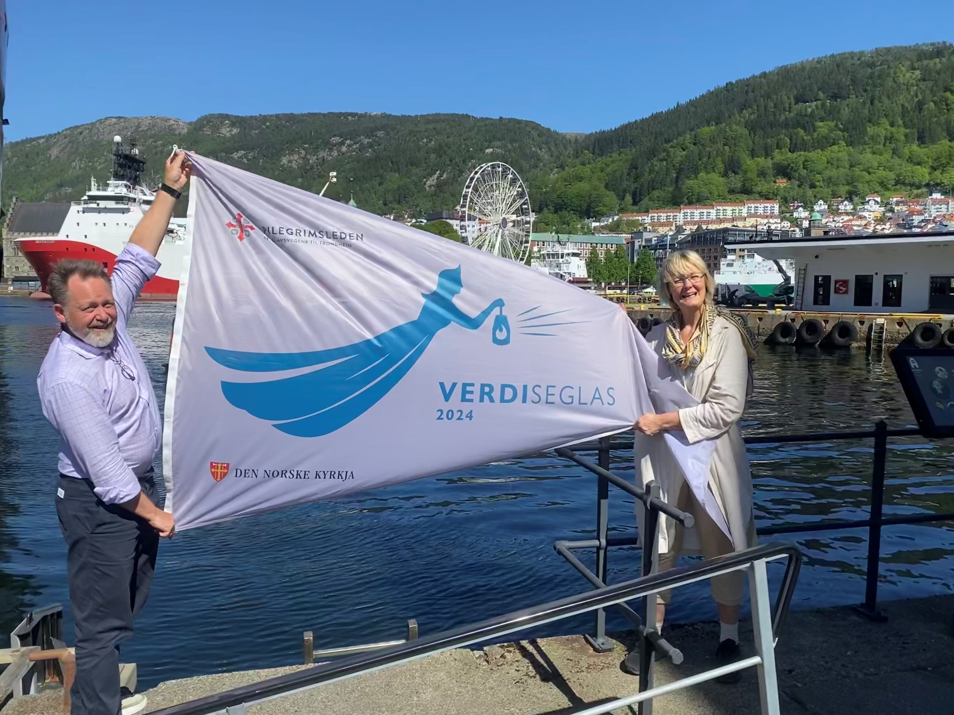 Einar Vegge og Ragna Sofie holder en vimpel med logoen til Verdiseglas 2024