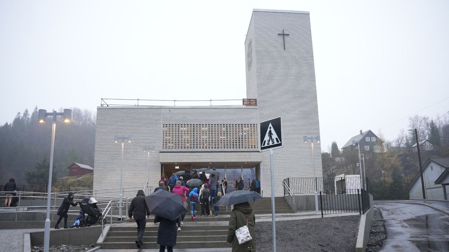 Kø inn i moderne kirke en regnværsdag. Foto