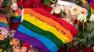 Et Pride flagg med en sterk beskjed, lagt over blomsterhavet som oppsto etter 25. juni 2022 i Oslo. Foto: Ivar Barane