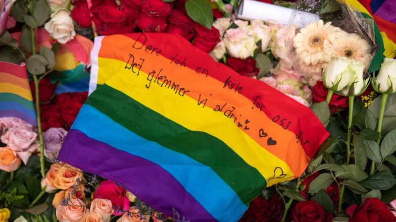 Et Pride flagg med en sterk beskjed, lagt over blomsterhavet som oppsto etter 25. juni 2022 i Oslo. Foto: Ivar Barane